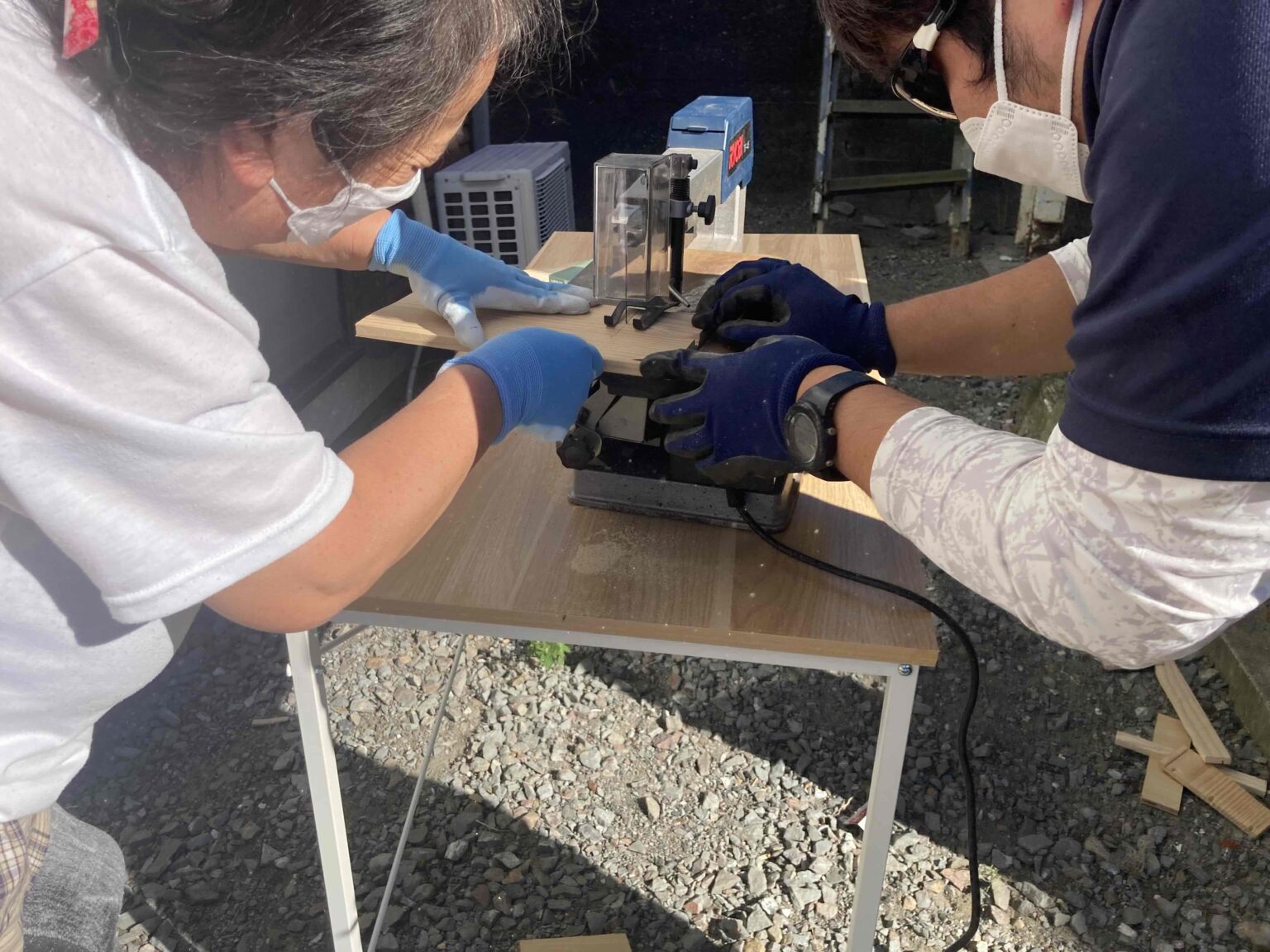 一緒に木工作業に取り組む利用者とスタッフ